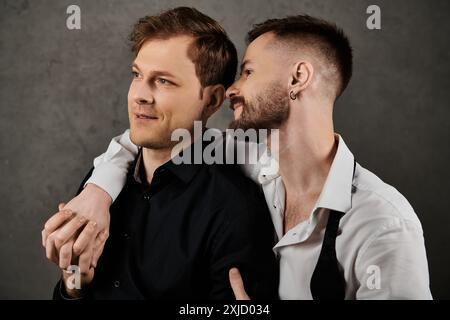 Zwei Männer in Anzügen umarmen sich in einem zärtlichen Moment. Stockfoto