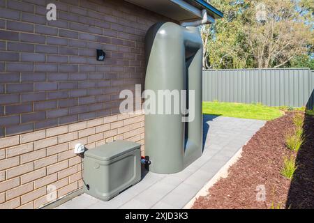 Regenwassertank mit Pumpkasten, verbunden auf dem Hinterhof eines neuen Vorstadthauses in South Australia Stockfoto