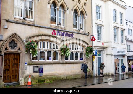 Filiale der Natwest Bank im Stadtzentrum von Wells mit Frau, die den Bankautomaten benutzt, um Bargeld abzuheben, Somerset, England, Großbritannien Stockfoto