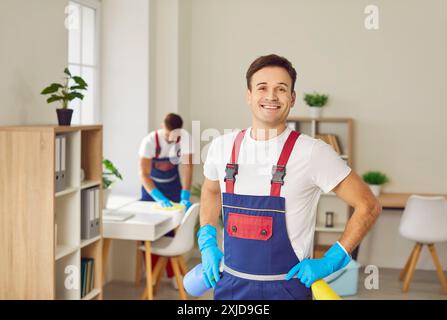 Gutaussehendes männliches Putzporträt posiert lächelnd, Mann arbeitet, professionelle Hausmeister-Service-Reinigung Stockfoto
