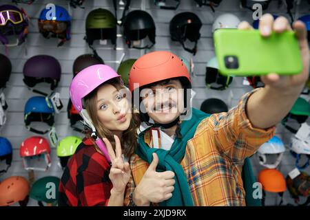 Fröhliches, liebevolles Paar, das Selfie im Fahrradhelm macht Stockfoto