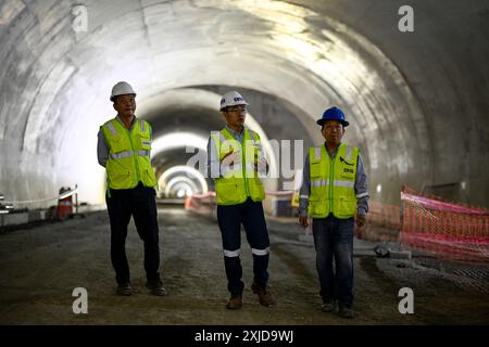 (240718) -- MEXIKO-STADT, 18. Juli 2024 (Xinhua) -- Pei Zhimin (C) spaziert auf der Baustelle des Machu Picchu Highway Tunnels in der Region Cusco in Peru, 23. Juni 2024. PEI Zhimin arbeitet seit zehn Jahren in Südamerika. 2014 begann er für sechs Monate in Venezuela zu arbeiten, dann zog er nach Brasilien, um dort den Markt zu entwickeln. Danach wurde er nach Bolivien geschickt und diente bis April 2019 als Chefingenieur für ein Autobahnprojekt. Derzeit arbeitet Pei sowohl als Projektmanager des Machu Picchu Highway Tunnels als auch als Ingenieur für die China Railway Tunnel Group Co., Ltd Als Projekt Stockfoto