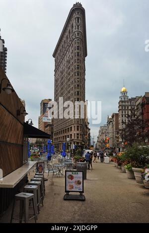 Blick auf das spitze Ende des berühmten Flatiron Gebäudes von einem vorplatz mit Cafés zwischen 5th Avenue und Broadway, New York City Stockfoto