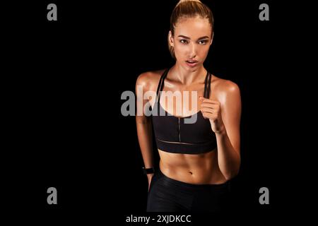 Sportliche Mädchen Jogging auf Schwarz Studio Hintergrund Stockfoto