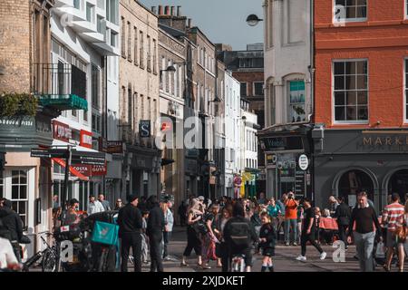 Cambridge, UK - 8. Oktober 2023 : Eine geschäftige Straßenszene in Cambridge, Großbritannien, mit Leuten, die an Geschäften und Restaurants vorbeilaufen. Stockfoto