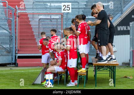 Cottbus, Deutschland. Juli 2024. Spieler und Funktionäre des FC Energie Cottbus stehen für ein Teamfoto im LEAG Energie Stadium an. Cheftrainer Claus-Dieter Wollitz (M) springt in seinen Sitz. Vermerk: Frank Hammerschmidt/dpa/Alamy Live News Stockfoto