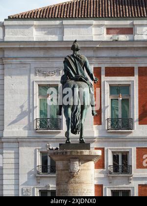 Eine vertikale hintere Aufnahme der Statue des spanischen Königs Karl III. Zu Pferd, vor einem historischen Gebäude in Madrid, Spanien Stockfoto