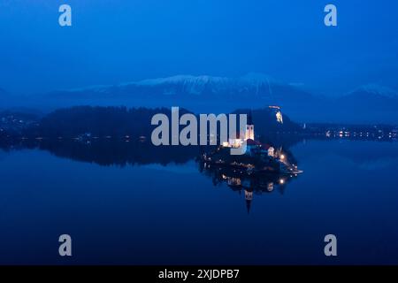 Bled Lake, Marijinega Vnebovzetja Kirche und Blejski Grad in der Abenddämmerung. Julianische Alpen und Reflexion im See. Slowenien, Europa. Luftaufnahme. Stockfoto