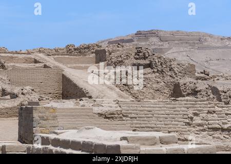 Die Echos der antiken Stadt: Alte Ruinen stehen der Zeit gegenüber. Alte Backsteinbauten an den historischen Pachacamac Ruinen unter klarem Himmel. Stockfoto