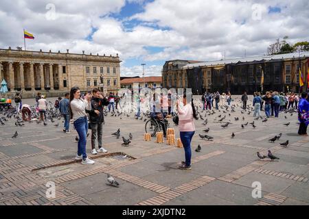 BOGOTA, KOLUMBIEN - 3. JULI 2024 - viele Touristen füttern Tauben mit Mais an einem sonnigen Tag an der Plaza de Bolivar Stockfoto