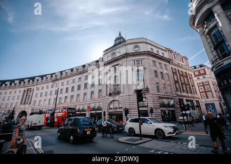 London, UK - 10. Oktober 2023 : Eine geschäftige Straßenszene in London mit einem roten Doppeldeckerbus, schwarzen Taxis und einem weißen SUV, der an einem großen orna vorbeifährt Stockfoto