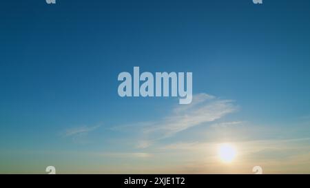 Zeitraffer. Orangeblauer Sonnenuntergang. Halo-Effekt vor Sonnenuntergang. Flugzeug im Flug bei Sonnenuntergang. Stockfoto