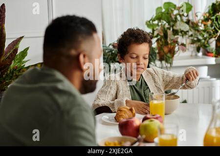 Mann und Frau, Afroamerikaner, genießen gemeinsam Frühstück am Tisch. Stockfoto