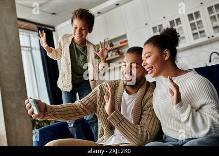 afroamerikanische Familie sitzt fröhlich zusammen auf einer leuchtend blauen Couch. Stockfoto
