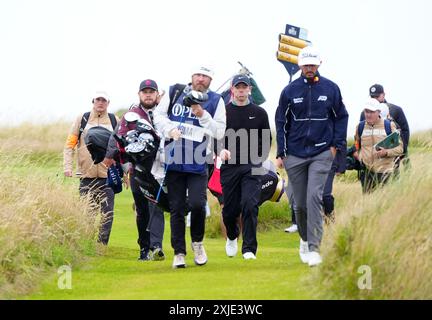 Rory McIlroy aus Nordirland, Max Homa aus den USA und Tyrrell Hatton aus England gehen am ersten Tag der Open in Royal Troon, South Ayrshire, Schottland. Bilddatum: Donnerstag, 18. Juli 2024. Stockfoto