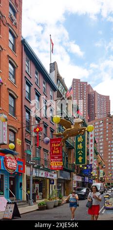 NYC Chinatown: Duellierende Fahnen – amerikanische, taiwanesische und chinesische Fahnen fliegen von benachbarten Gebäuden auf der schmalen Pell Street im Herzen von Chinatown. Stockfoto