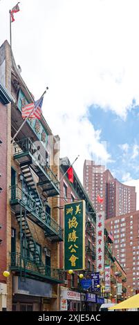 NYC Chinatown: Duellierende Fahnen – amerikanische, taiwanesische und chinesische Fahnen fliegen von benachbarten Gebäuden auf der schmalen Pell Street im Herzen von Chinatown. Stockfoto