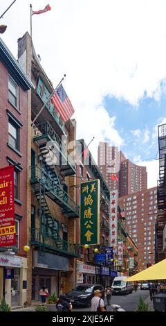 NYC Chinatown: Duellierende Fahnen – amerikanische, taiwanesische und chinesische Fahnen fliegen von benachbarten Gebäuden auf der schmalen Pell Street im Herzen von Chinatown. Stockfoto