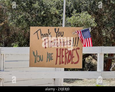 Santa Ynez, Kalifornien, USA. Juli 2024. Vielen Dank an die Feuerwehrleute! Ihr seid Heldenschild auf der HAPPY CANYON ROAD während des Lake Fire und eine amerikanische Flagge. (Kreditbild: © Amy Katz/ZUMA Press Wire) NUR REDAKTIONELLE VERWENDUNG! Nicht für kommerzielle ZWECKE! Stockfoto