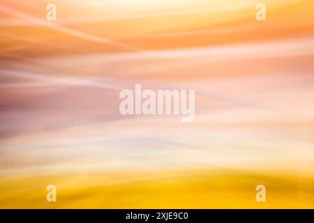 Abstrakter Bewegungsunschärfeeffekt. Farbenfroher Hintergrund in gelben Orangetönen. Verschwommener welliger Hintergrund. Hintergrund Stockfoto