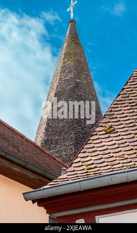 Kirchturm und Dächer der umliegenden Häuser. Sommer in der Stadt. Mit Fliesen bedeckte Dächer. Gebäude einer deutschen Kleinstadt. Stockfoto