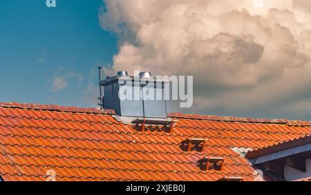 Dachlüftungskamin. Luftfilter. Metallkonstruktion. Giebeldach mit Fliesen. Ökologische Filter. Stockfoto