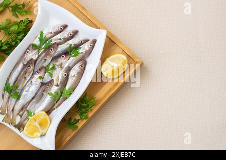 Frische, ungekochte Schellfisch-Fische in Keramikschale auf dem Tisch, roher Wittling-Fisch-Konzept Stockfoto