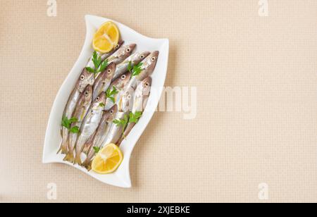 Frische, ungekochte Schellfisch-Fische in Keramikschale auf dem Tisch, roher Wittling-Fisch-Konzept Stockfoto