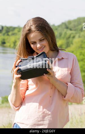 Die junge Frau benutzt Virtual-Reality-Brillen in der Natur Stockfoto