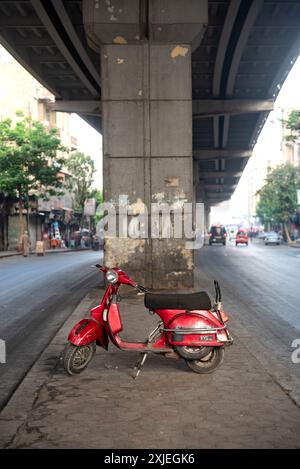 Kairo, Ägypten. Juli 2024 Ein cool aussehender roter Roller, der unter einem Betonüberschlag im Downtown District der ägyptischen Hauptstadt Kairo geparkt wurde. Stockfoto