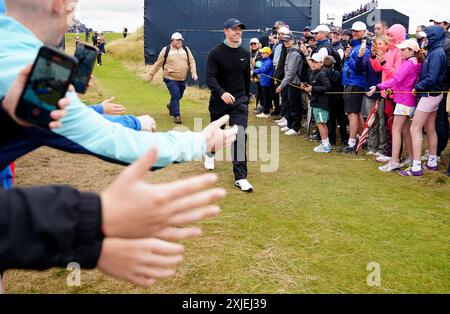 Der nordirische Rory McIlroy lächelt, als er am ersten Tag der Open in Royal Troon, South Ayrshire, Schottland, an den Zuschauern vorbeiläuft. Bilddatum: Donnerstag, 18. Juli 2024. Stockfoto