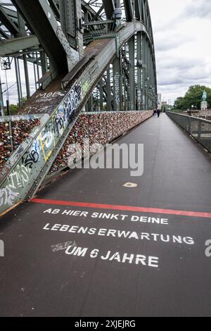 Slogan auf der Hohenzollernbrücke „von hier fällt Ihre Lebenserwartung um 6 Jahre“, Köln, Deutschland. Der Slogan soll die Aufmerksamkeit auf den lenken Stockfoto