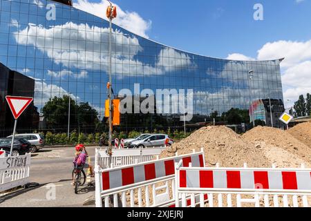 Baustellenbarrieren an der Bonner Straße, Glasfassade eines Bürogebäudes, Sandpfähle, Kind wartet an einer Ampel, Köln, Deutschland. Ba Stockfoto