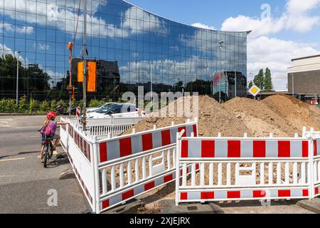 Baustellenbarrieren an der Bonner Straße, Glasfassade eines Bürogebäudes, Sandpfähle, Kind wartet an einer Ampel, Köln, Deutschland. Ba Stockfoto