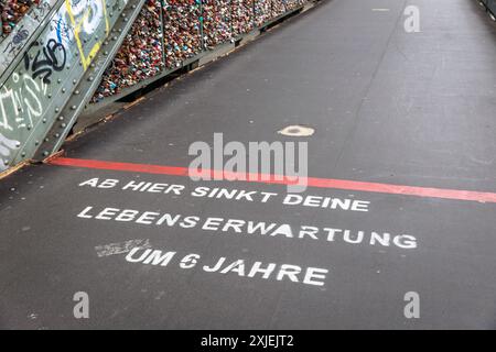 Slogan auf der Hohenzollernbrücke „von hier fällt Ihre Lebenserwartung um 6 Jahre“, Köln, Deutschland. Der Slogan soll die Aufmerksamkeit auf den lenken Stockfoto