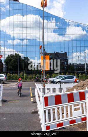 Baustellenbarrieren an der Bonner Straße, Glasfassade eines Bürogebäudes, Kind wartet an einer Ampel, Köln, Deutschland. Baustellenabsp Stockfoto