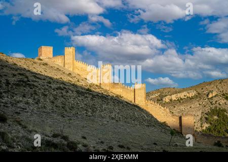 Blick auf die Verteidigungsanlage der mittelalterlichen Mauern von Albarracín, Teruel, Aragon, Spanien, mit goldenem Abendlicht und der Stadt im Hintergrund Stockfoto