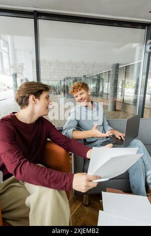 Zwei junge Männer, die zusammen in einer Bibliothek studieren. Stockfoto