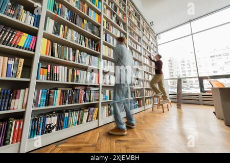 Zwei junge männliche Studenten studieren in Büchern in der Bibliothek. Stockfoto