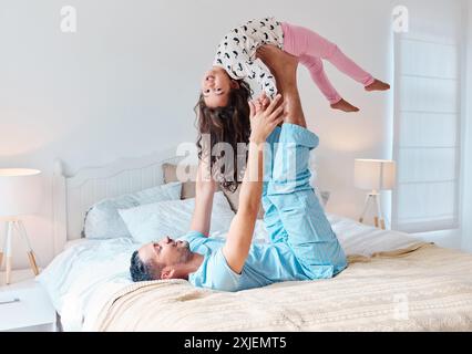 Kind, Vater und fliegen mit Mädchen im Bett für Flugzeugspiel, Spiel oder Balance im Schlafzimmer. Liebe, Unterstützung und glücklicher Mann, der das kleine Kind zum Spaß hebt Stockfoto