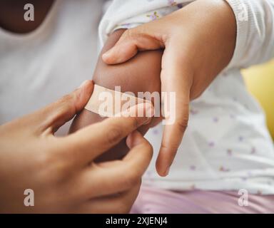 Eltern, Hände und Kind mit Gips für Verletzungen, Blutergüsse oder Schmerzen am Arm in Pflege, Vertrauen oder Unterstützung zu Hause. Nahaufnahme des Vormunds, der Jungen Verband auflegt Stockfoto