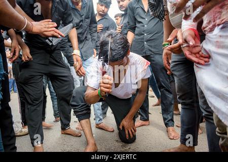 Neu-Delhi, Delhi, Indien. Juli 2024. Ein indischer schiitischer Muslim führt ein Ritual der Selbstgeißelung mit einem Messer während einer Muharram-Prozession durch, die Ashura in den alten Vierteln von Delhi, Indien, markiert. Muharram ist der erste Monat des islamischen Kalenders und gilt als einer der heiligsten Monate. Es ist eine Zeit der Trauer und des Gedenkens für schiitische Muslime, die an das Martyrium von Imam Hussain, dem Enkel des Propheten Muhammad, während der Schlacht von Karbala gedenken. (Kreditbild: © Mohsin Javed/ZUMA Press Wire) NUR REDAKTIONELLE VERWENDUNG! Nicht für kommerzielle ZWECKE! Stockfoto