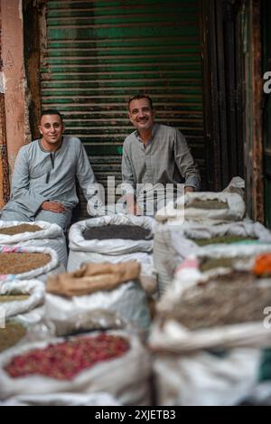 Kairo, Ägypten. Juli 2024. Zwei ägyptische Männer sitzen zwischen Säcken mit Gewürzen auf dem Kairoer Gewürzmarkt in der Nähe des belebten Einkaufsbazars Khan el Khalili, der bei Einheimischen und Touristen beliebt ist. Quelle: SOPA Images Limited/Alamy Live News Stockfoto