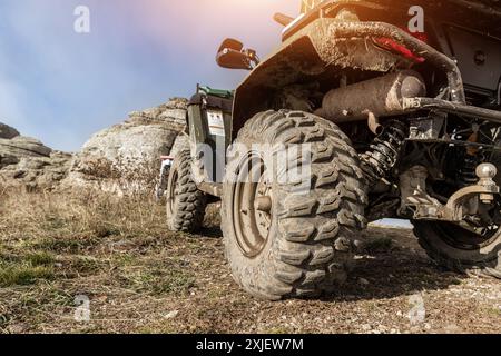 Nahaufnahme Detail untere POV-Ansicht 4x4 awd ATV Fahrzeug auf Schotterpiste unbefestigte Straße im Herbst auf nebligen Berggipfel. Offroad Auto Berg Safari Abenteuer Stockfoto