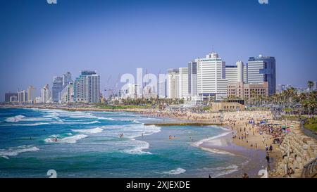 Tel Aviv, Israel, Strandpromenade, Hochhäuser, Skyline, Baukräne, Stadtstrand, Tourismus, Menschenmenge, Sonniger Tag, Badegäste, modernes Stadtbild, Mittelmeer, Küste, urbaner Strand, Erholung, Urlaub, Surfer, Wellen, klares Wasser, Sandstrand, Sommer, Freizeit, Küstenlinie, Bauprojekte, Metropole, Badewetter, Stadtleben, Strandbesucher, Architektur, Sonnenbaden, Meerblick, Skyline von Tel Aviv, Stadtentwicklung, städtischer Tourismus, israelische Küste, Urlaubsparadies, belebter Strand, Wasseraktivitäten, Küstenstadt. *** Tel Aviv, Israel, Strandpromenade, Wolkenkratzer, Skyline, Aufbau c Stockfoto