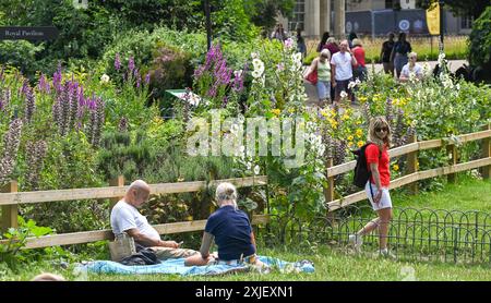 Brighton Großbritannien 18. Juli 2024 - Besucher genießen heute die heiße Sonne und die Blumen in Brightons Royal Pavilion Gardens, da morgen eine Hitzewarnung für den Südosten ausgegeben wurde, die Temperaturen voraussichtlich 30 Grad erreichen wird: Credit Simon Dack / Alamy Live News Stockfoto