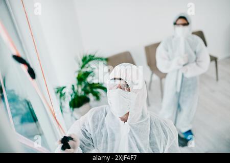 Reinigung, Schutz und Gruppe von Ärzten mit Wissenschaftlern in Gefahrgut-psa zur Verhinderung der Verbreitung des Virus. Virologe, Ausbruch oder Menschen, die Raum für desinfizieren Stockfoto