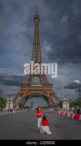 Paris, Frankreich - 07 17 2024: Blick auf zwei asiatische Frauen, die vor dem Eiffelturm mit den olympischen Ringen von den seine-Kais posieren Stockfoto