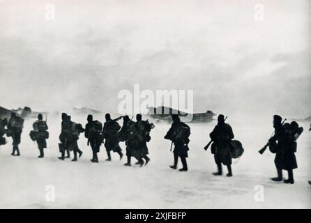 Ein Foto zeigt Soldaten, die während der Operation Barbarossa 1941 durch eine schneebedeckte Landschaft in Richtung Junkers Ju 52-Flugzeuge laufen. Trotz eisiger Temperaturen von -30°C sind die Flugzeuge bereit, ein Sturmbataillon an die Front zu transportieren, während die deutschen Truppen gegen sowjetische Truppen an der Ostfront vorrücken. Stockfoto