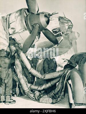 Ein Foto zeigt flexible Rohre, die Wärme von einem Auto auf die Motoren eines Dornier DO 17 übertragen. Dieser Prozess gewährleistet die Funktionalität unter den Frostbedingungen an der Ostfront. Diese Methode wurde 1941 während der Operation Barbarossa eingesetzt und war für den deutschen Vormarsch gegen die sowjetischen Truppen von entscheidender Bedeutung. Stockfoto